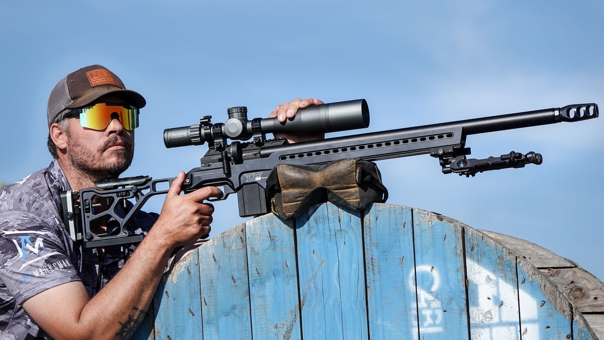 a hunter holding a DRS Pro Chassis -based rifle with a scope